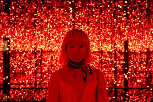 A young woman fully saturated in bright red light
