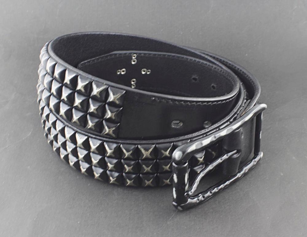 A worn studded leather belt. Its fastened with one of two signature buckles.