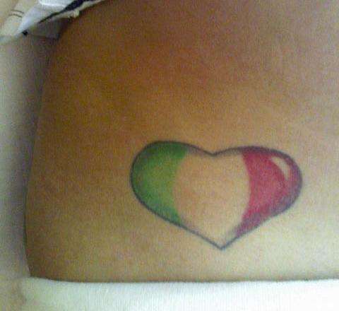 Heart tattoo, on the inside of her left hip, colored like the flag of Italy.