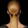 Long blonde hair is bound back into a sensible low ponytail.