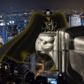 Female figure, all yellow-black, yellow stripe up each leg and along each arm. Barb wire belt with demon-bat buckle. Skull with some sort of bronze mask over the mouth. Dark cloak and cowl. Crouched on an eagle gargoyle on NYC's Chrysler Building.