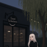 Ravenna and Takoda outside her cafe, Sweet Enchantments. (This is a different style and the cafe looks more modern.)