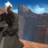 A screenshot of Clydwyn in Shaaloani. His wings are hidden. He sits on the ledge of a gorge in the middle of a bright day. Two waterfalls flow into the river in the background.