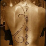 Swirls are on both sides of her spinal tattoo and would be petals and foxfires not diamonds.